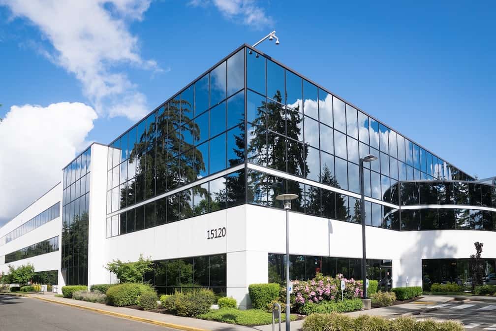 commercial building with window reflection and blue skies