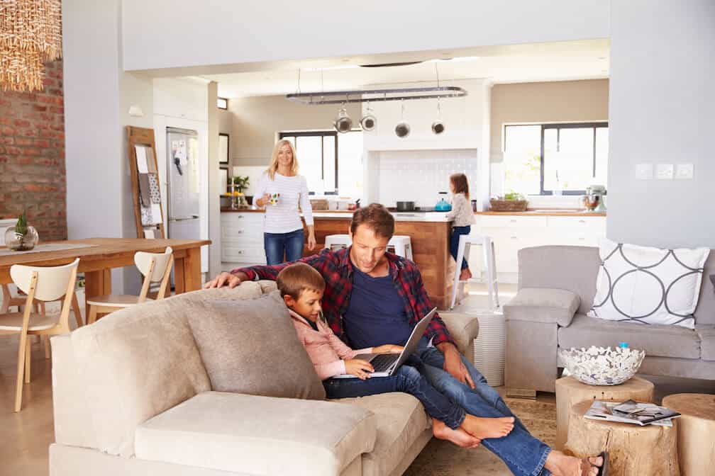 father and son sitting on a couch playing on a computer